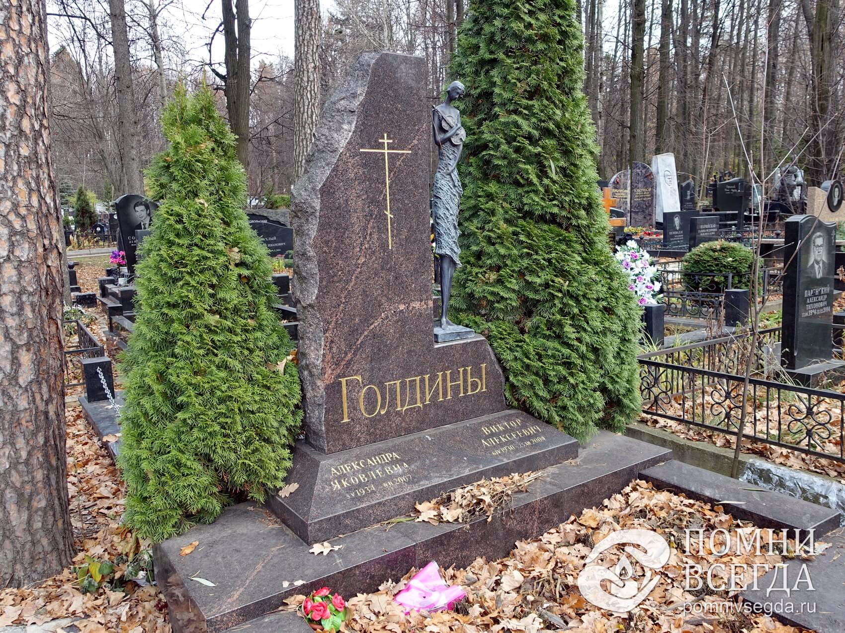 Надгробье со скульптурой скрипачки в окружении двух туй