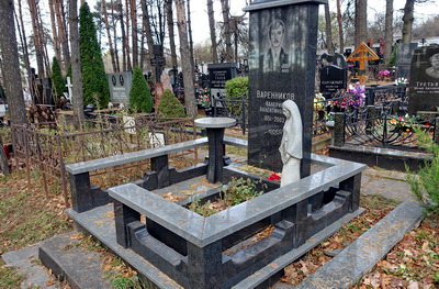 Простое гранитное надгробье прямоугольной формы и статуя плакальщицы